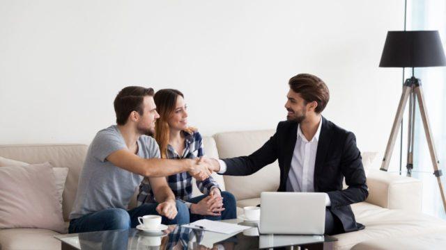 a-couple-and-their-property-manager-sitting-on-a-couch