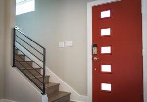 inside home with red front door and staircase leading upstairs on the left hand side