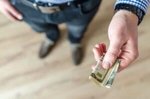 person handing over a wad of cash